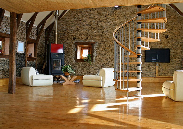 A living room with a spiral staircase and a fireplace