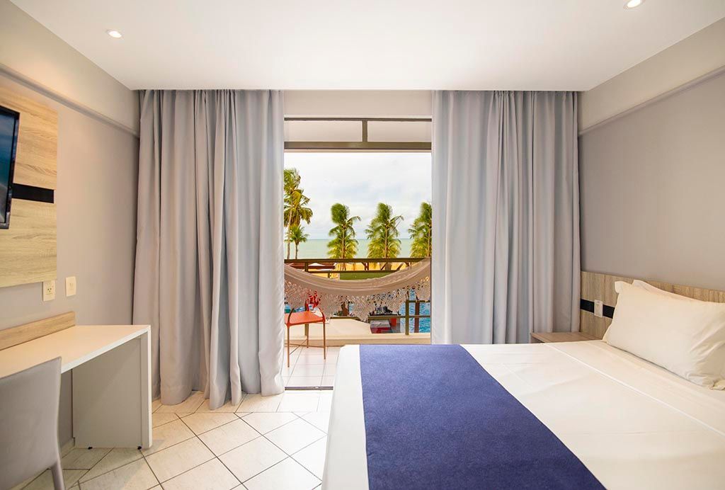 Um quarto de hotel com cama. Netuanah Praia Hotel