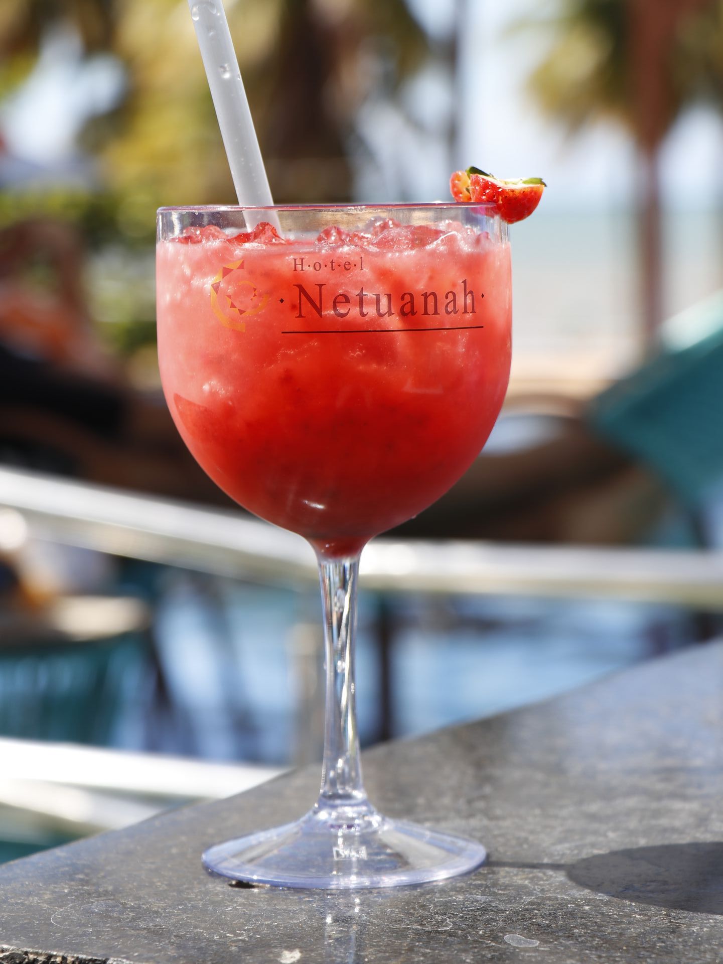 Um coquetel de morango em uma taça de vinho com canudo. Netuanah Praia Hotel