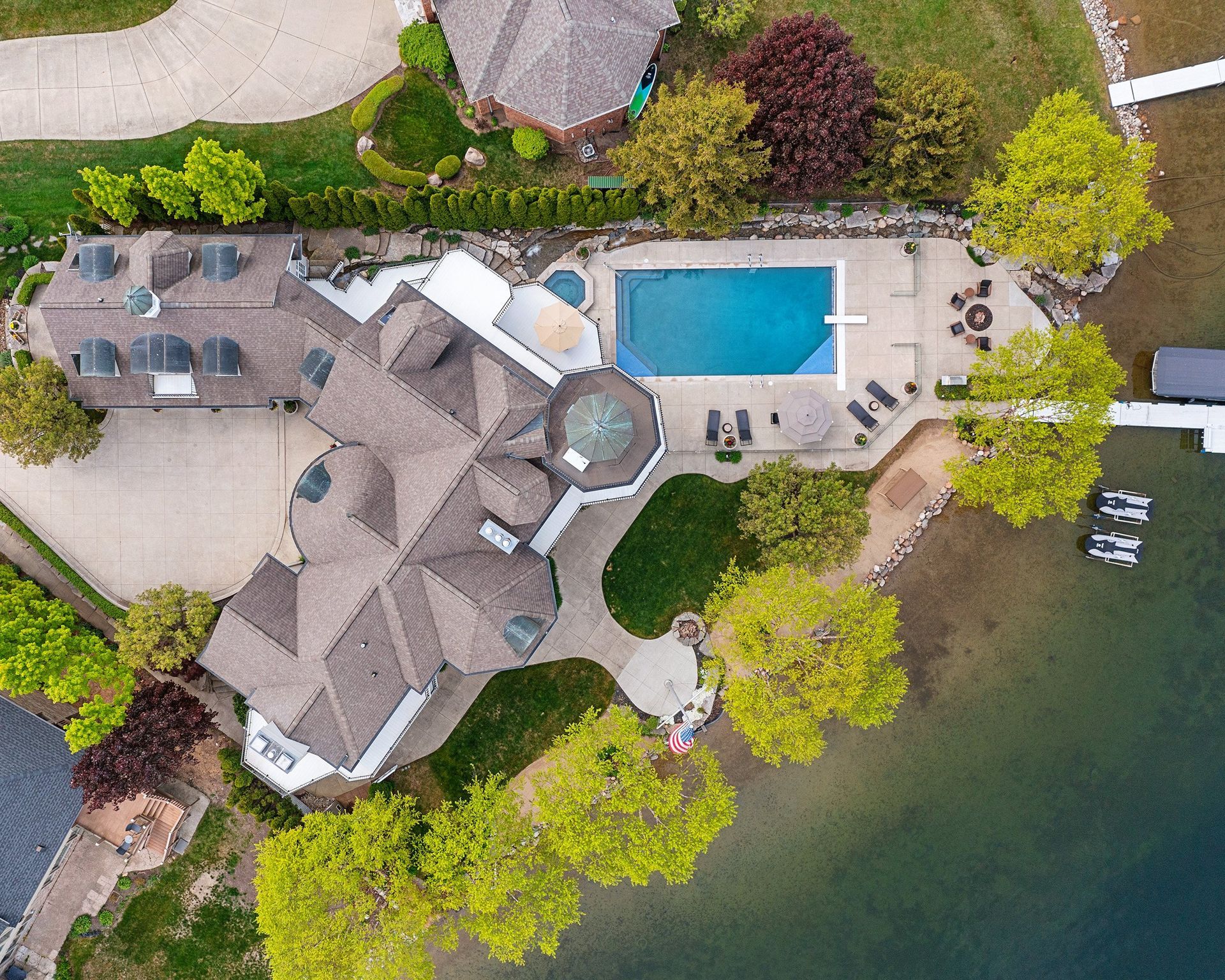 aerial photo of luxury home showing pool, dock, and seating area