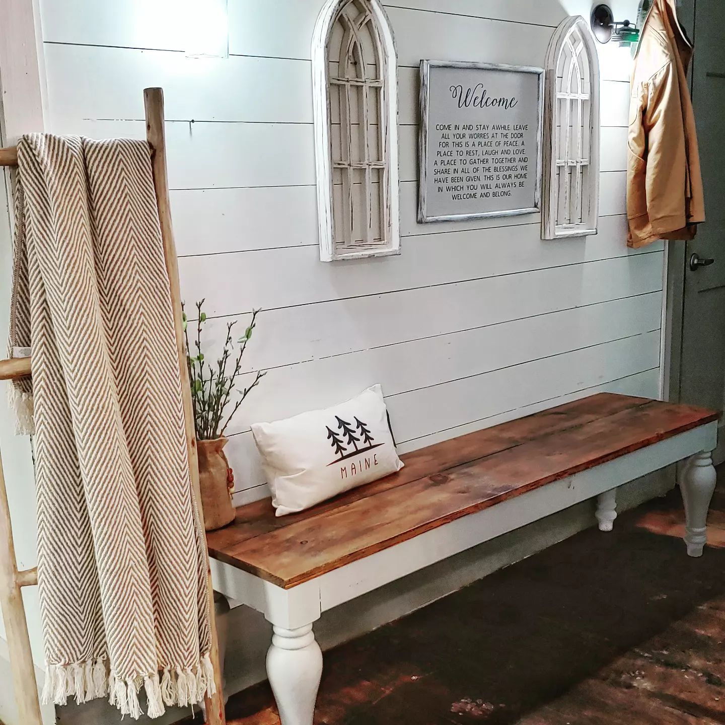A wooden bench with a pillow on it in a hallway.