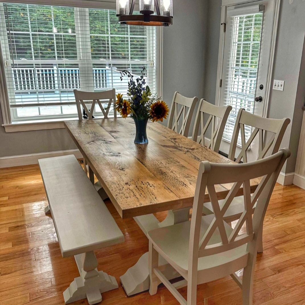 A dining room table with a vase of flowers on it