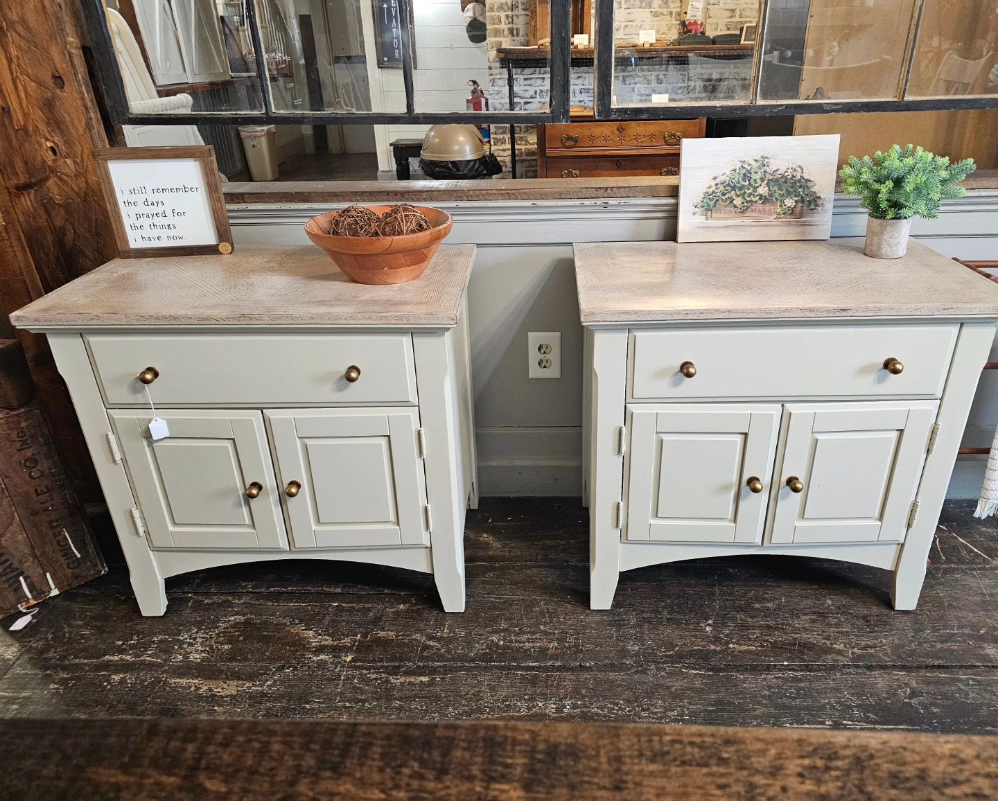 Two white nightstands are sitting next to each other on a wooden floor.