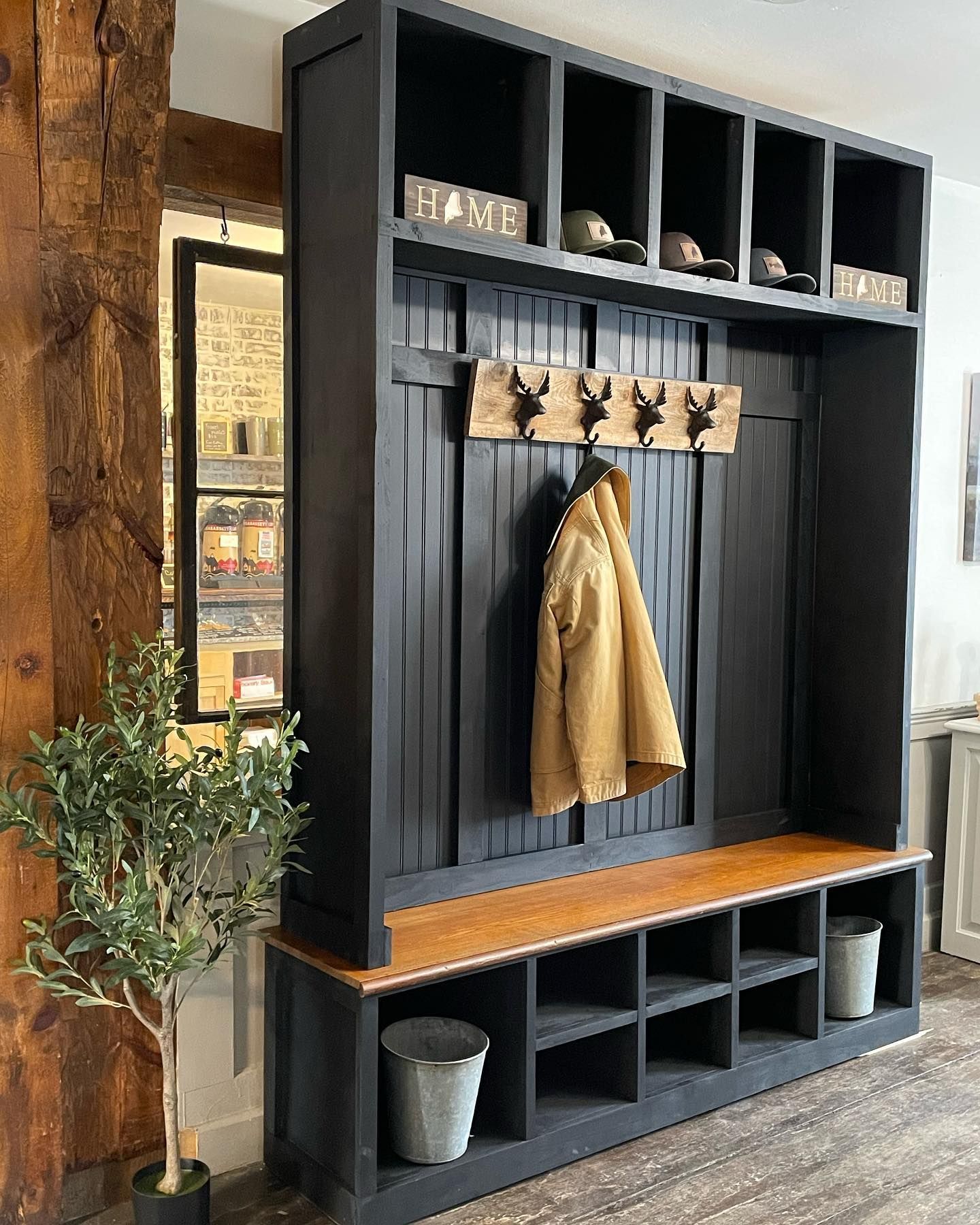 A coat is hanging on a rack in a mud room.