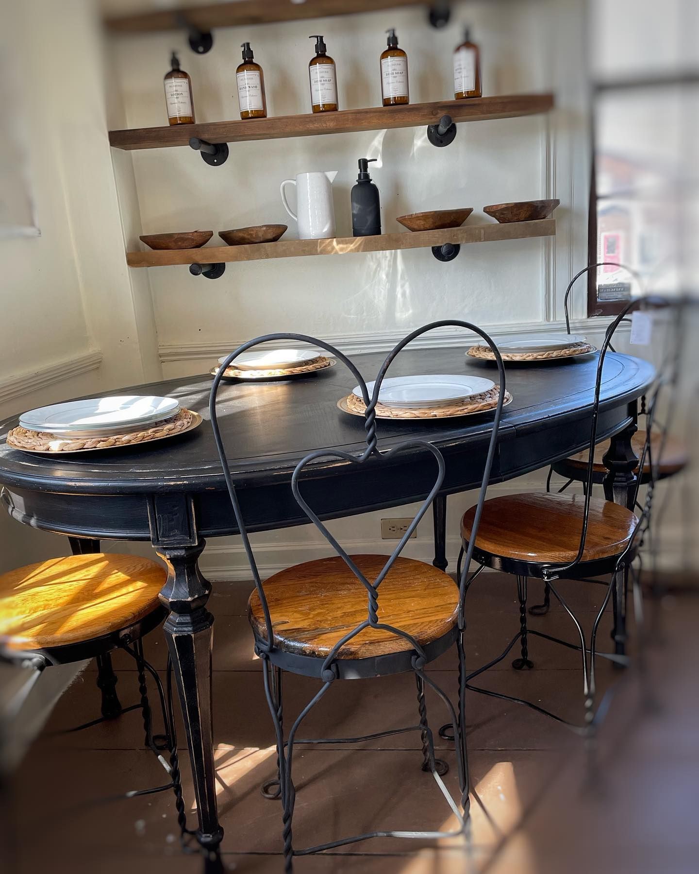 A dining room with a table and chairs and plates on it