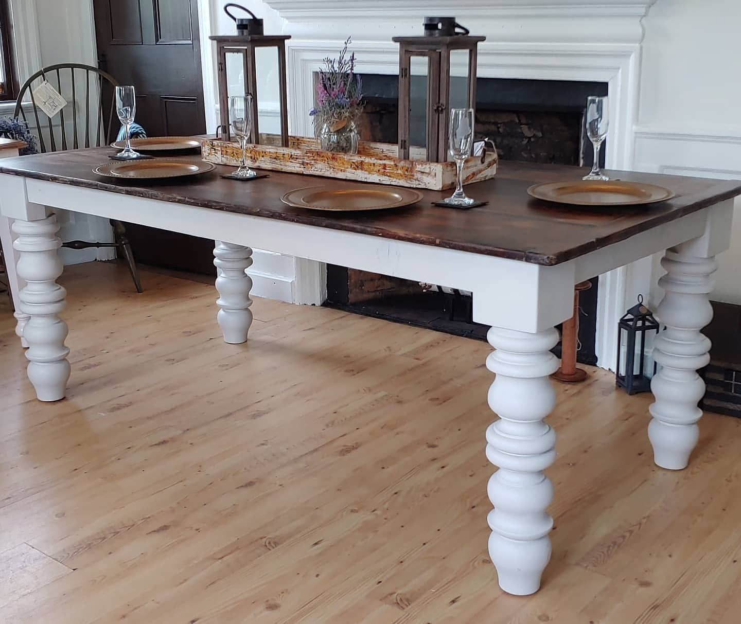 A wooden table with white legs and plates on it