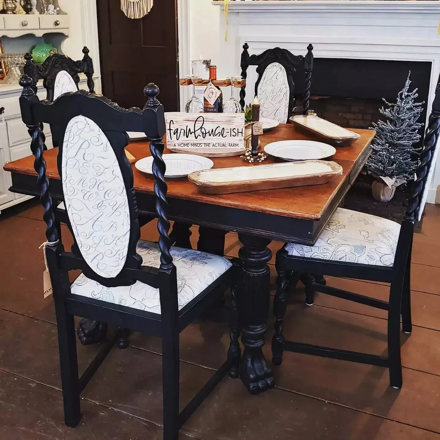 A dining room table and chairs with plates and a sign that says home sweet home