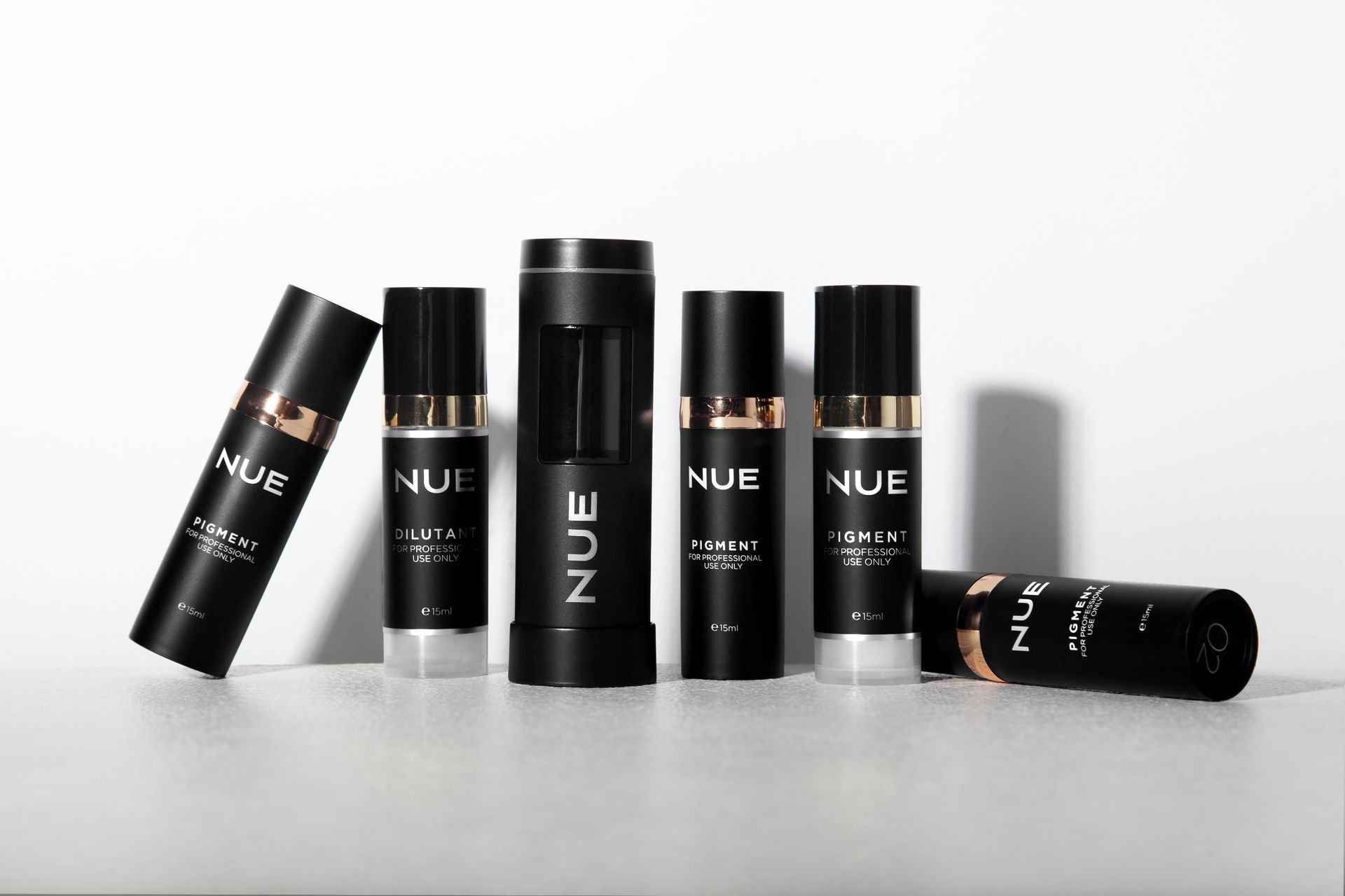 A group of bottles of nue cosmetics are lined up on a table.