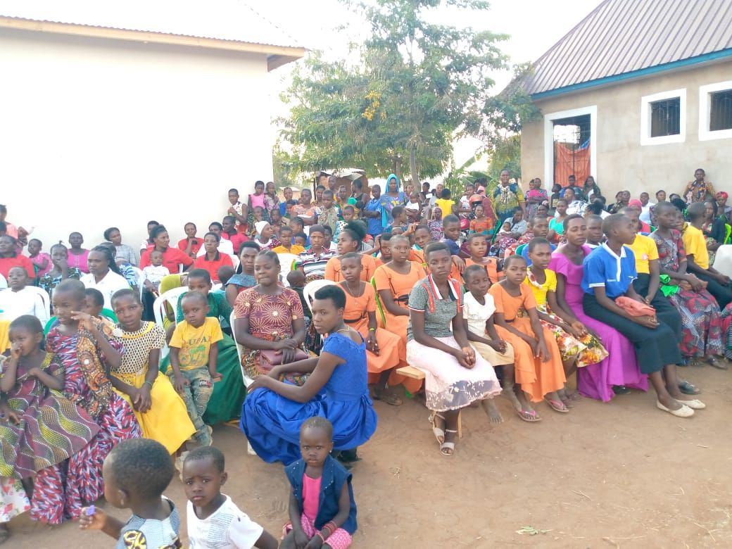 A large group of people are sitting in front of a building.