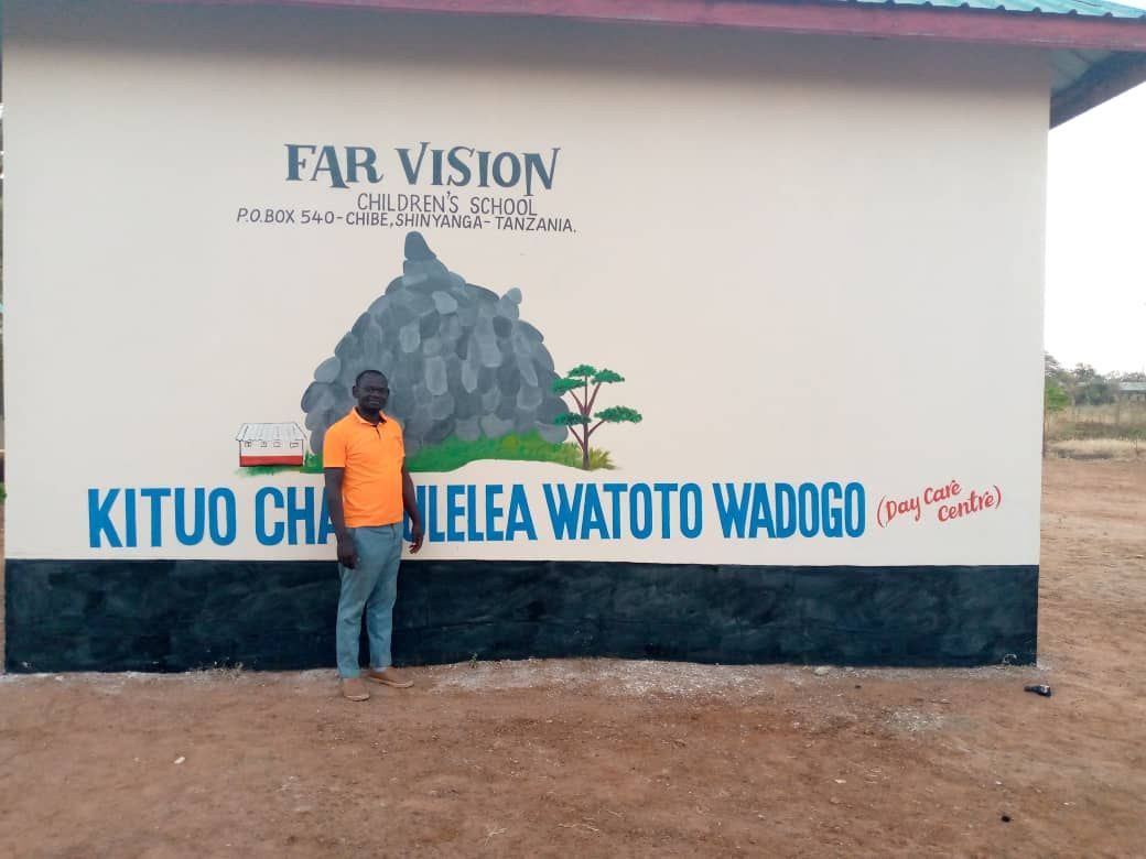 A man is standing in front of a wall that says far vision