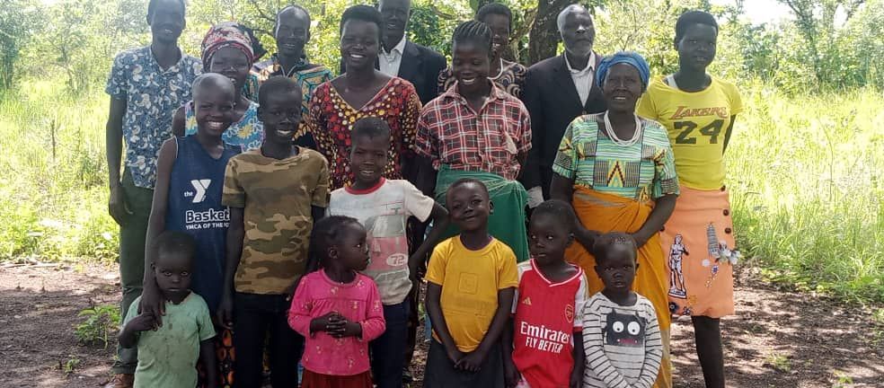 A group of people are posing for a picture in a field.