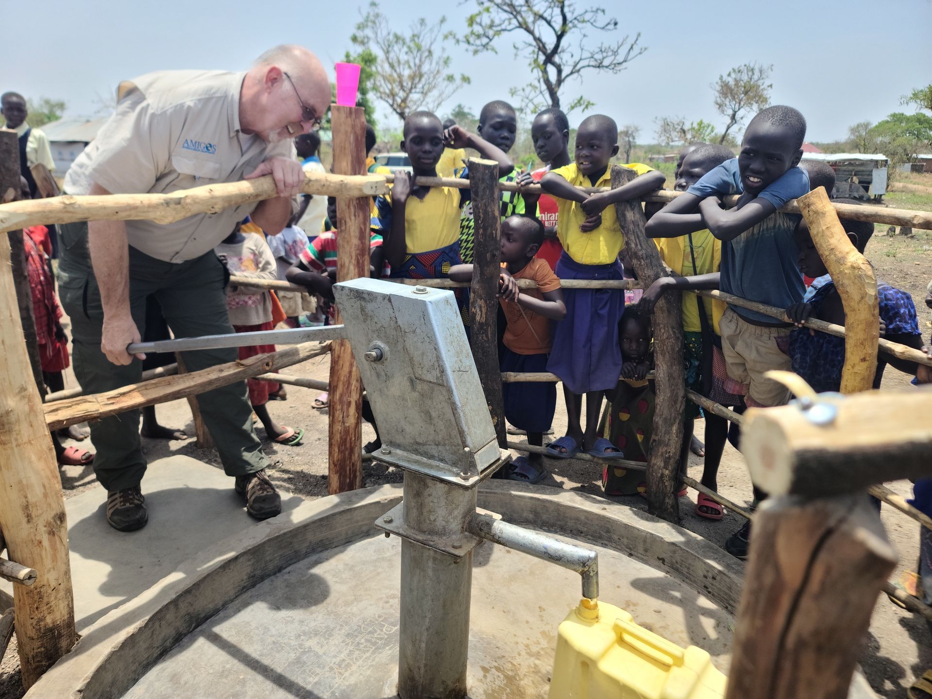 CEO pumps water at the newly drilled water well

