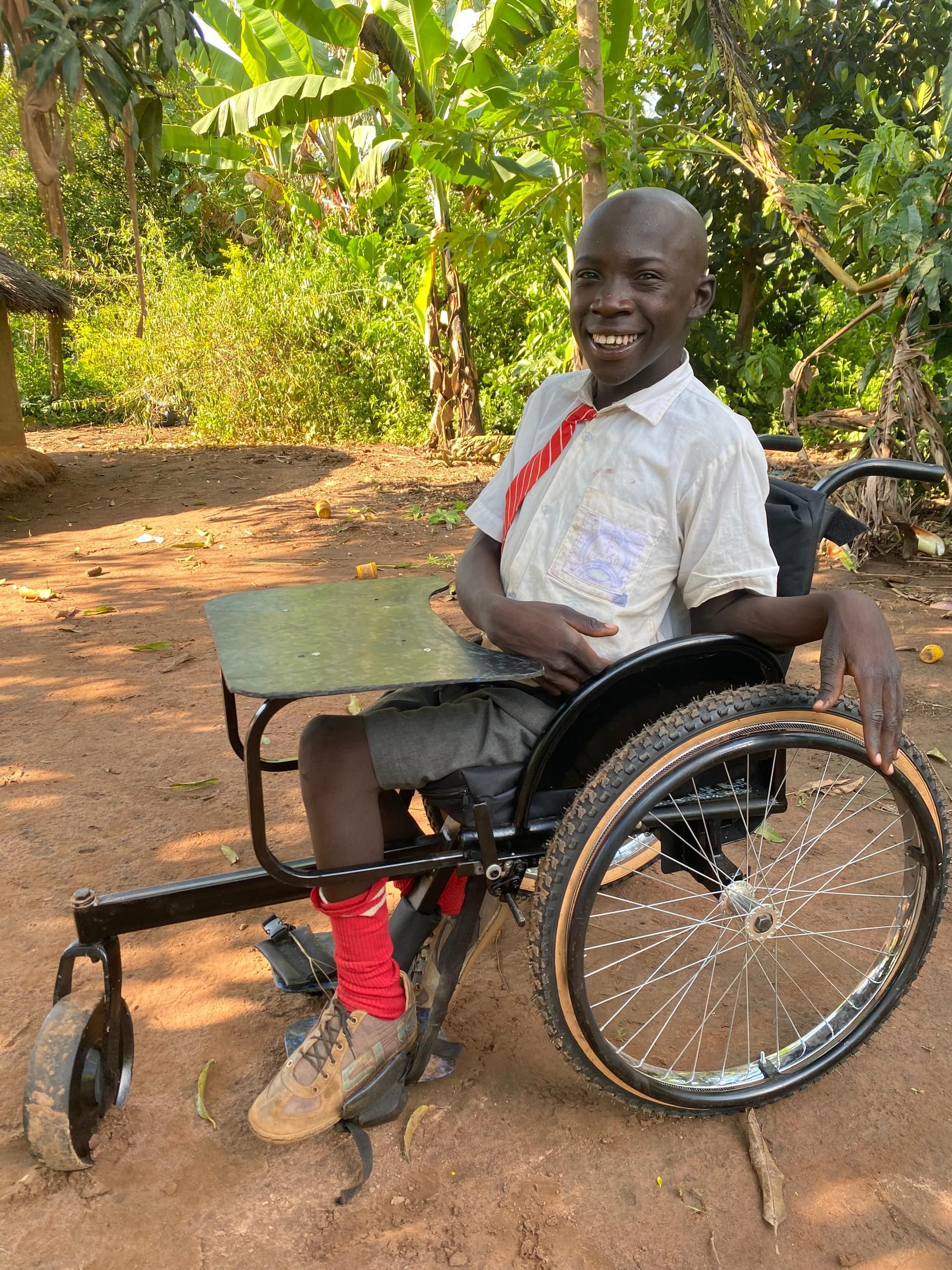 New Wheelchair Balaam received to go to school, wearing school uniform.