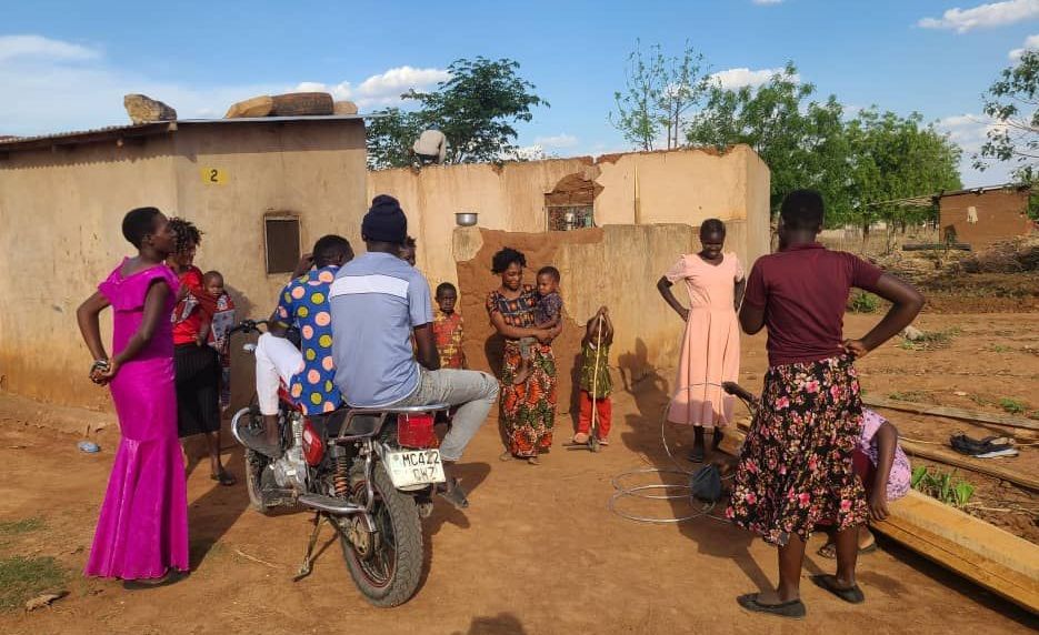 A group of people are standing around a motorcycle.