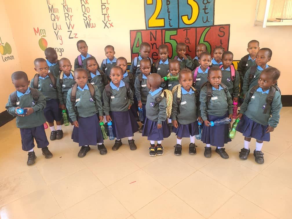 A group of children standing in front of a wall with the number 215 on it