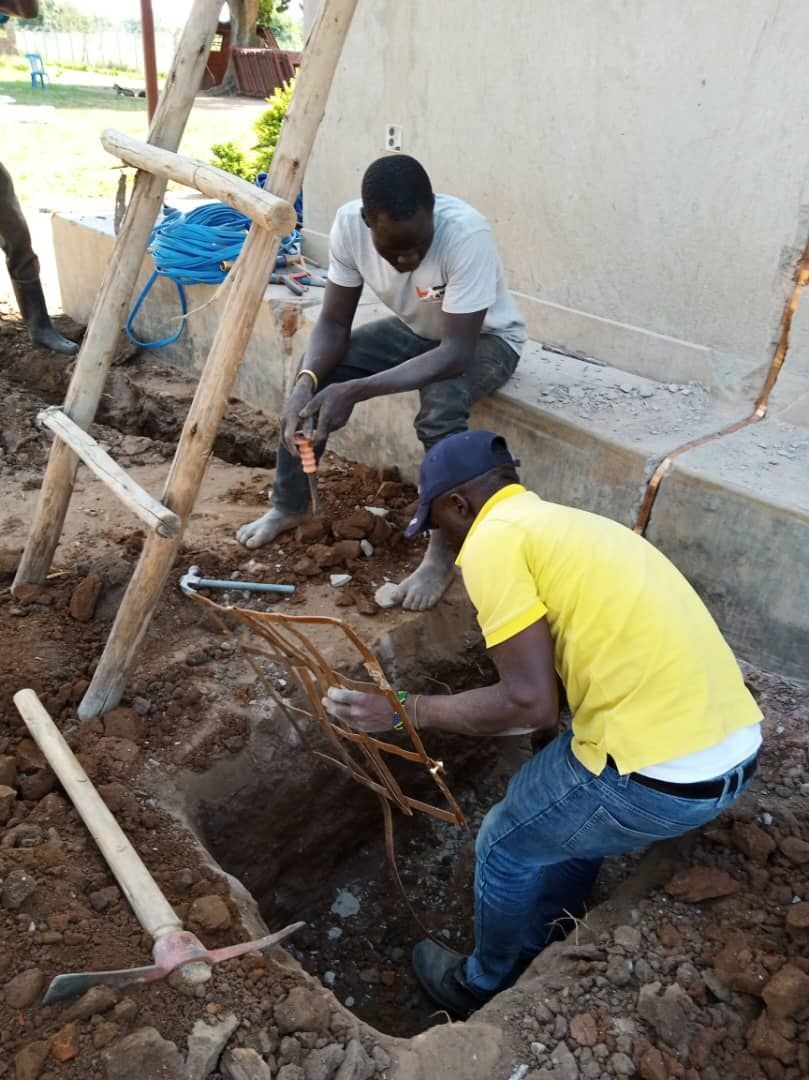 Two men are working in a hole in the ground.