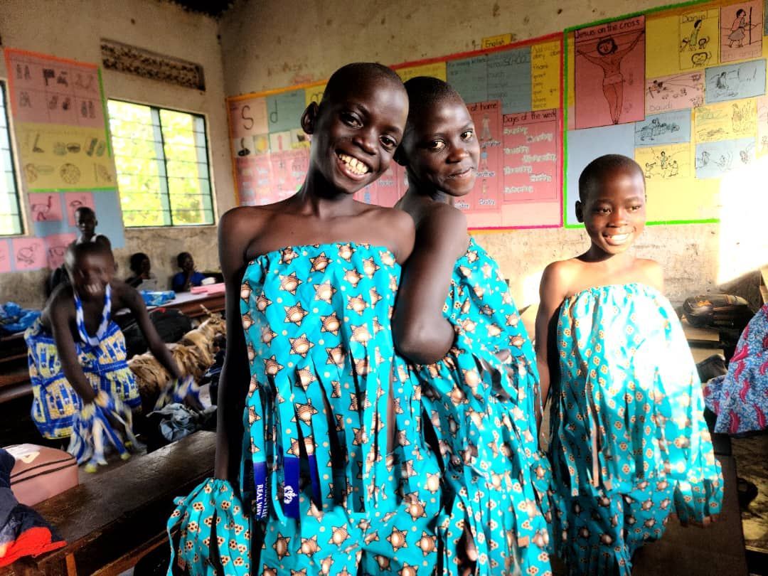 A group of young girls are posing for a picture in a classroom.