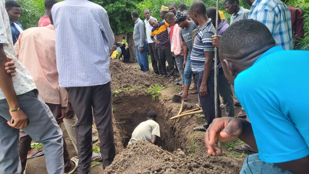 church members stop to help dig a grave.