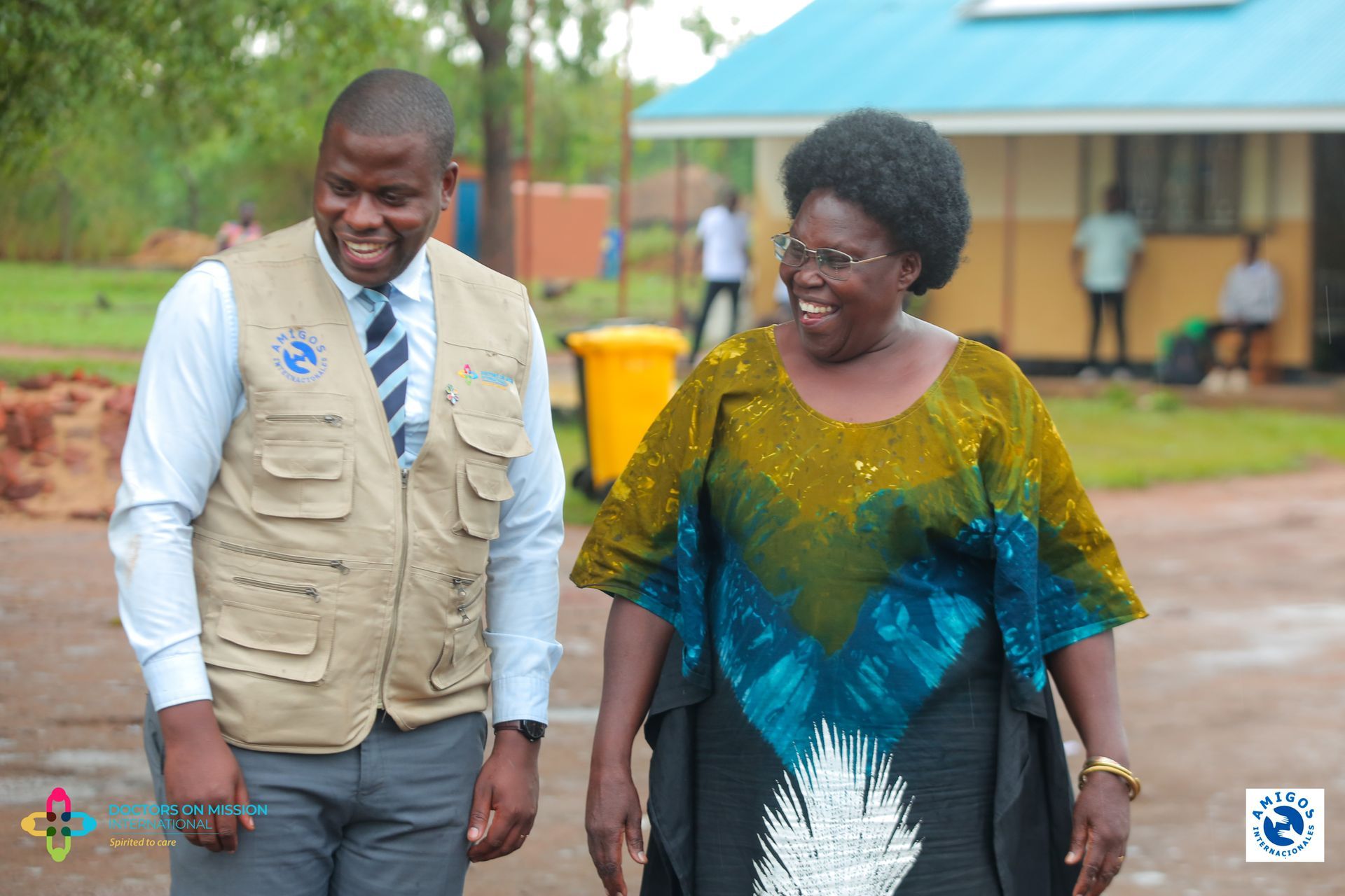 A man and a woman are standing next to each other in front of a building.