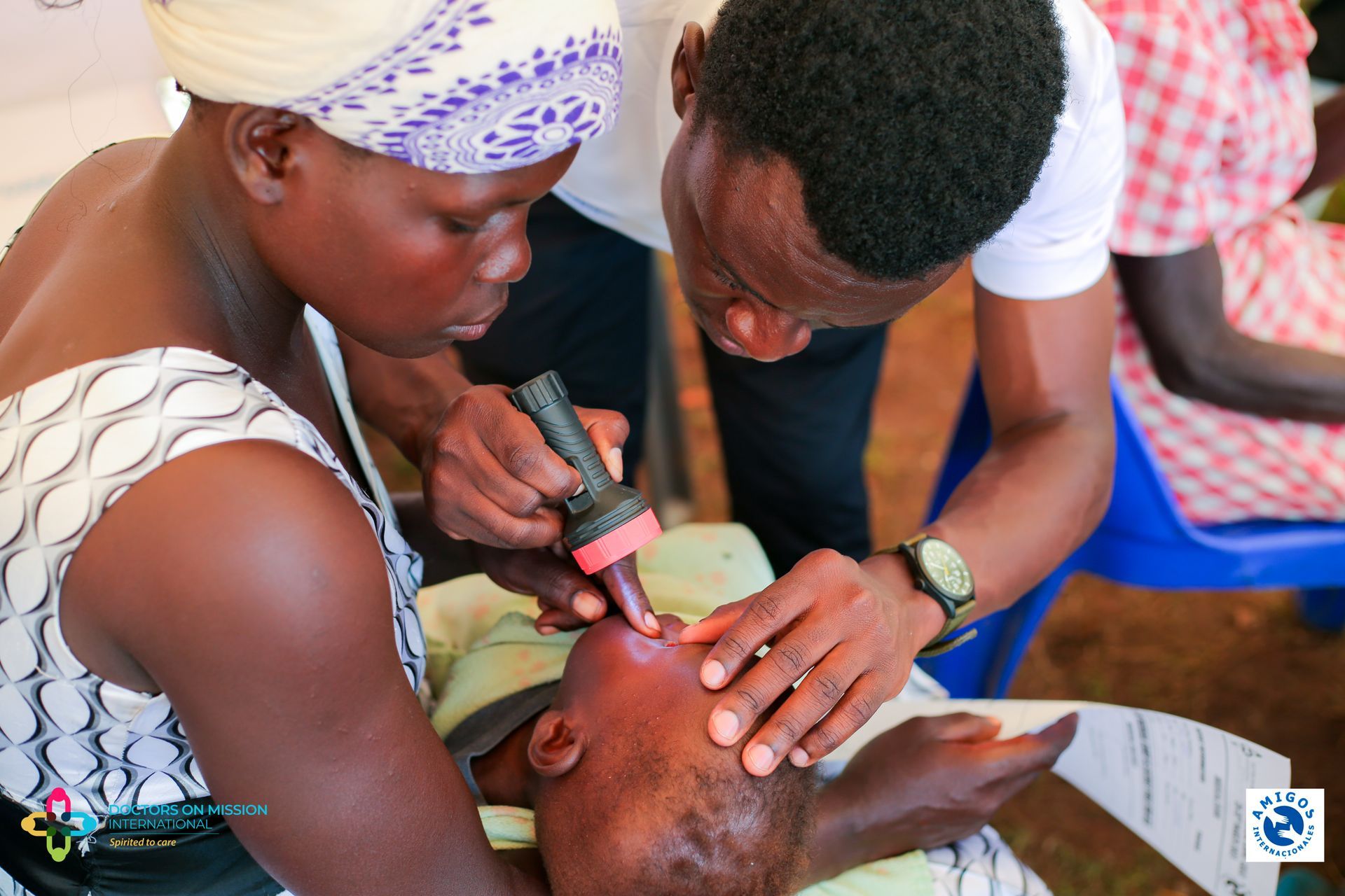 A man and a woman are examining a baby 's eyes.