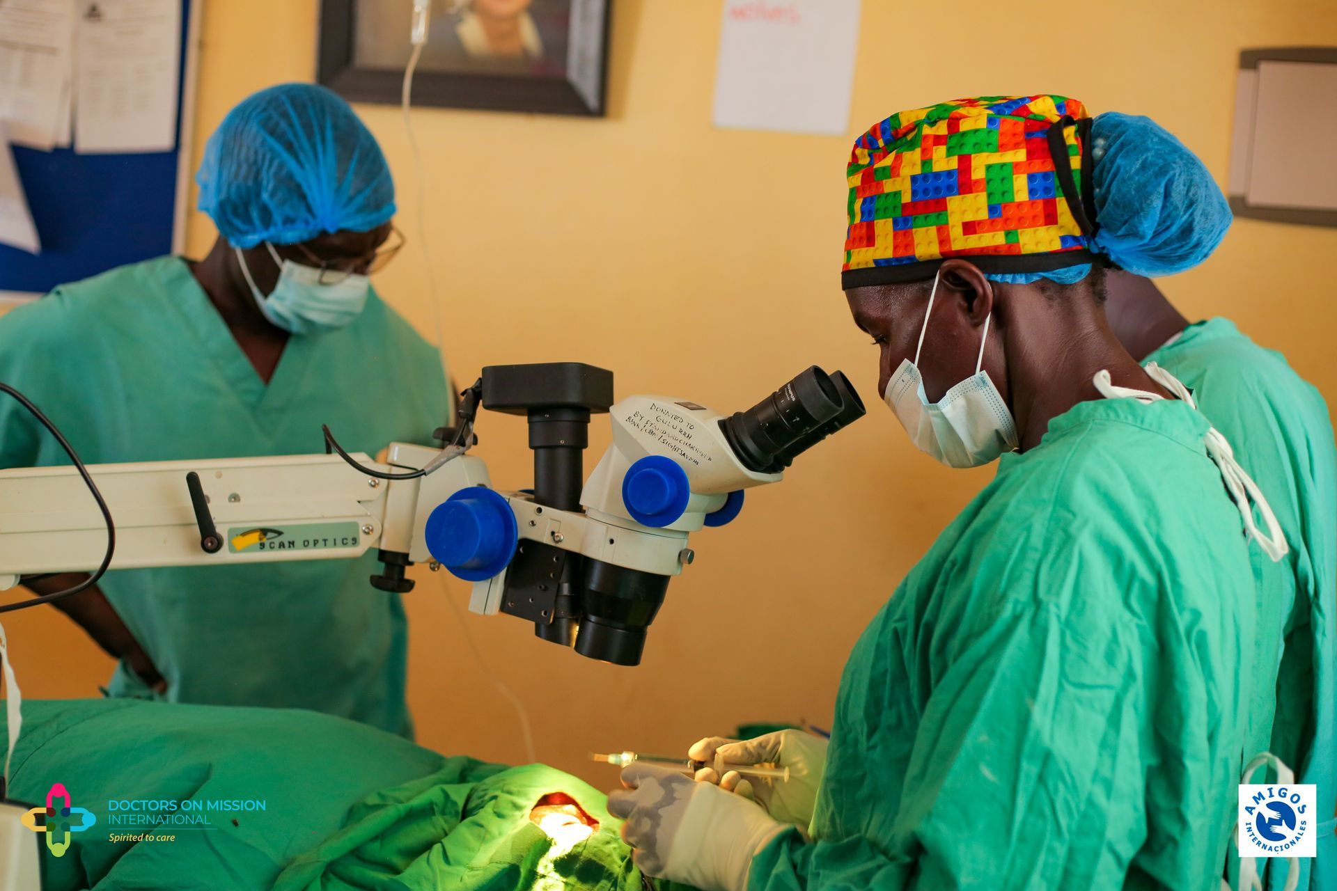Two surgeons are working on a patient with a microscope