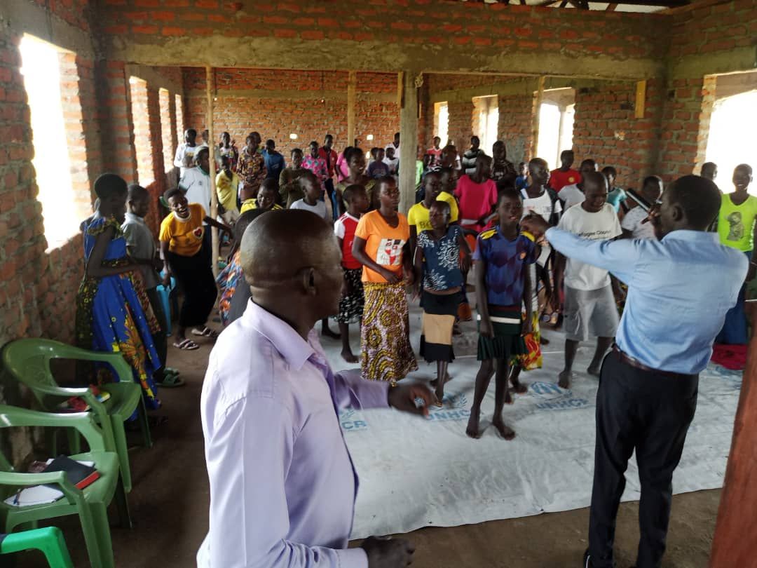 A man is standing in front of a large group of people