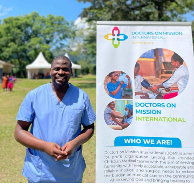 A man standing next to a doctors on mission international sign