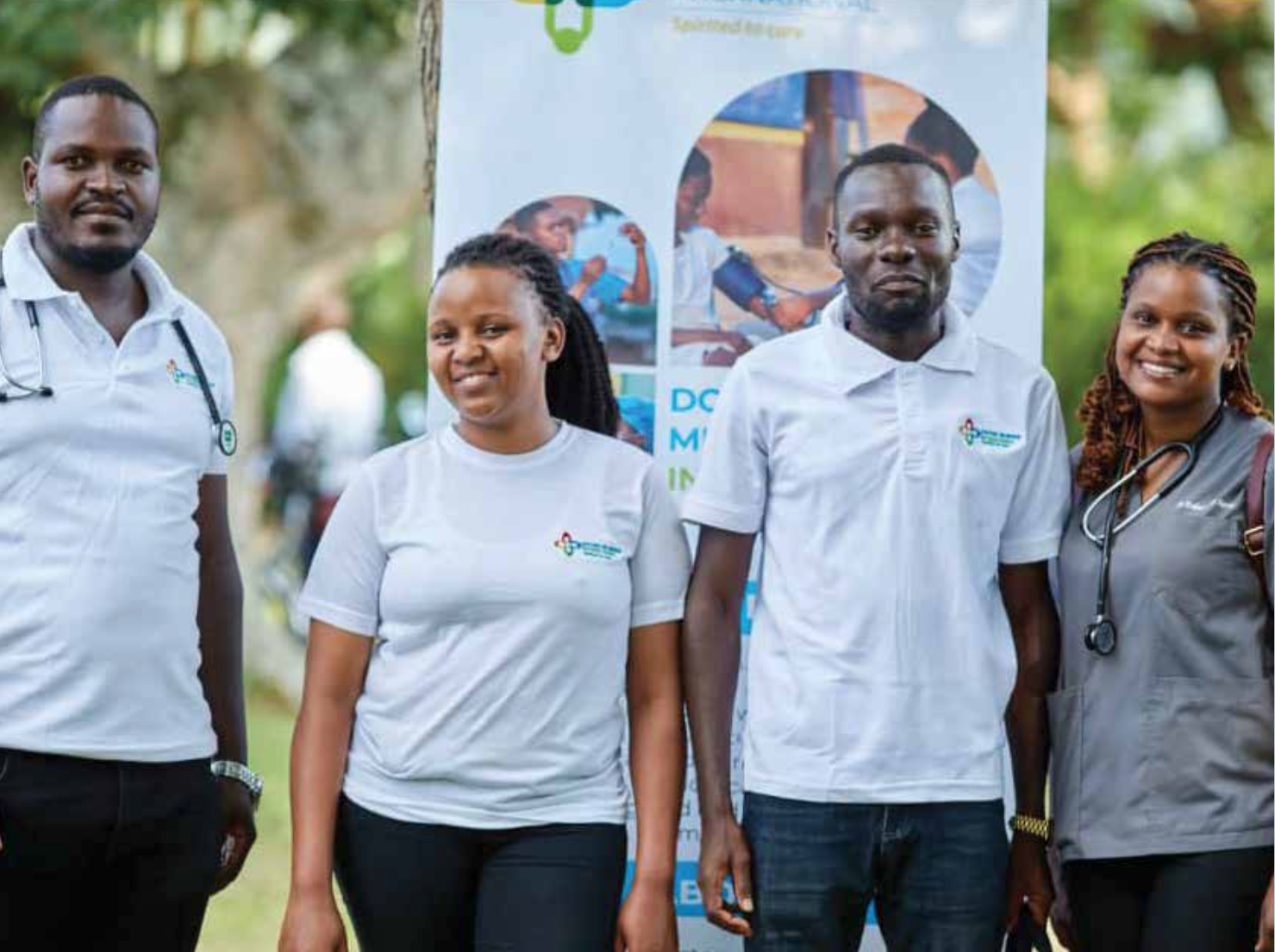 A group of people standing next to each other in front of a sign.