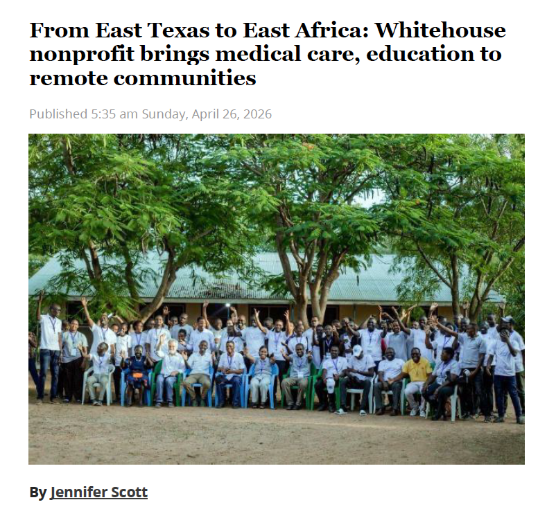 Large group posing outdoors under trees in front of a building, with a news headline above.