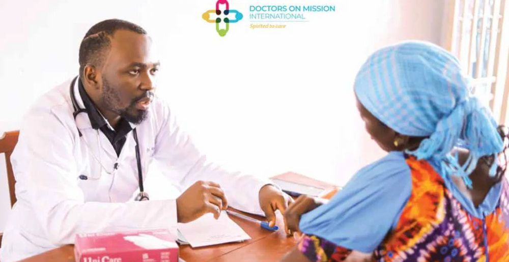 Doctor consulting with patient; white coat, stethoscope. Patient wearing blue head covering.