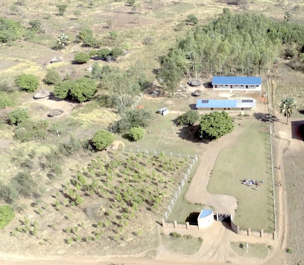 An aerial view of a house in the middle of a field