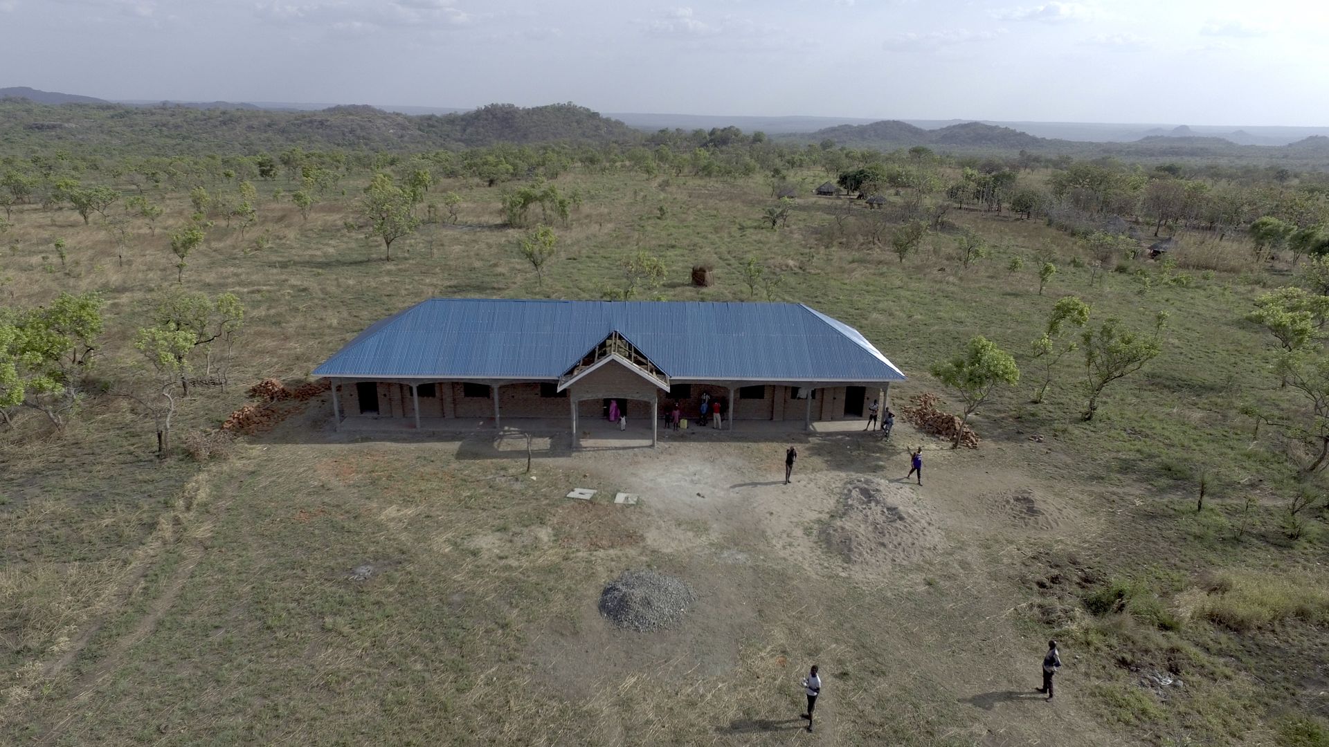 An aerial view of a house in the middle of a field.