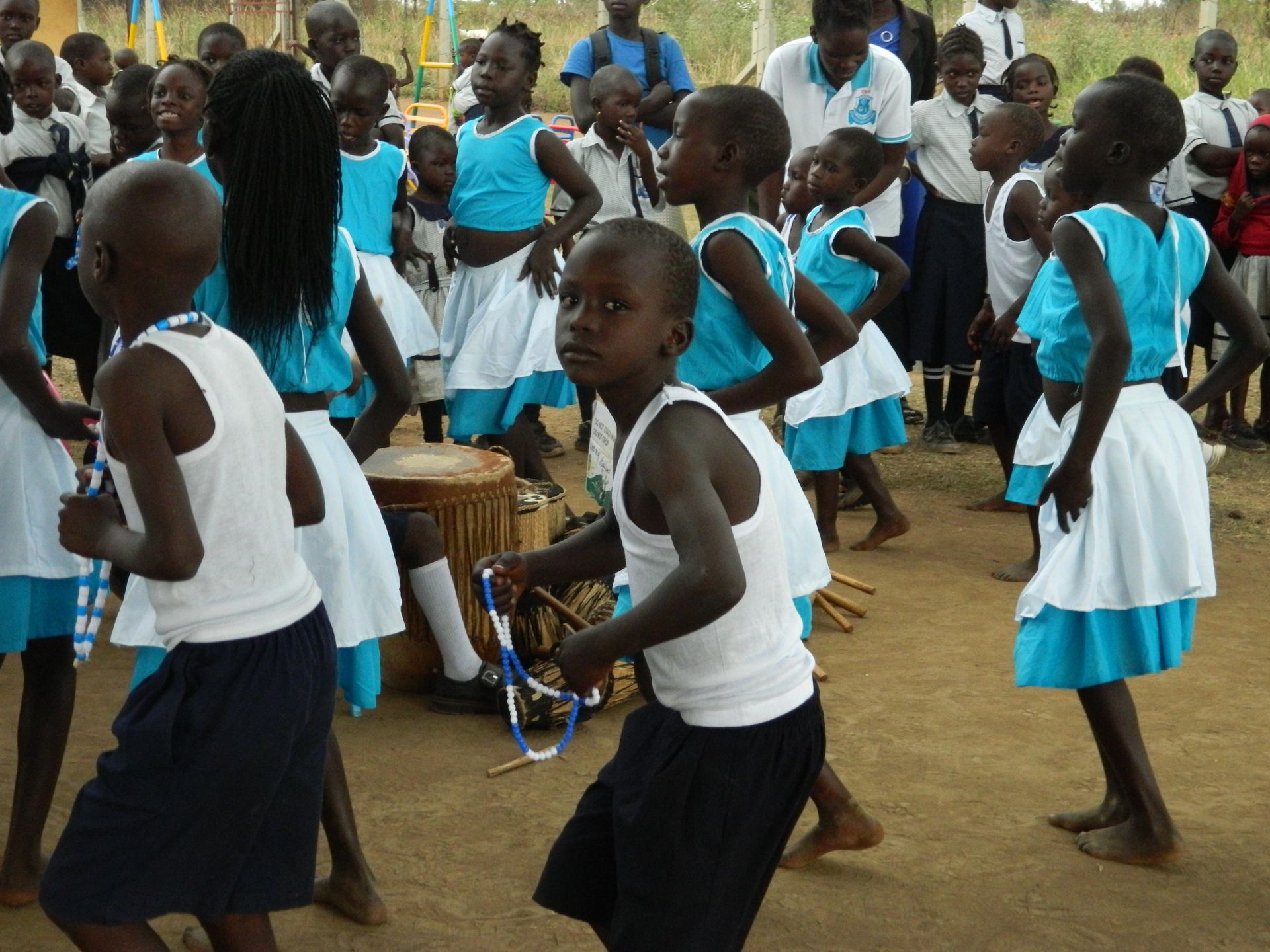 A group of children are dancing in front of a drum