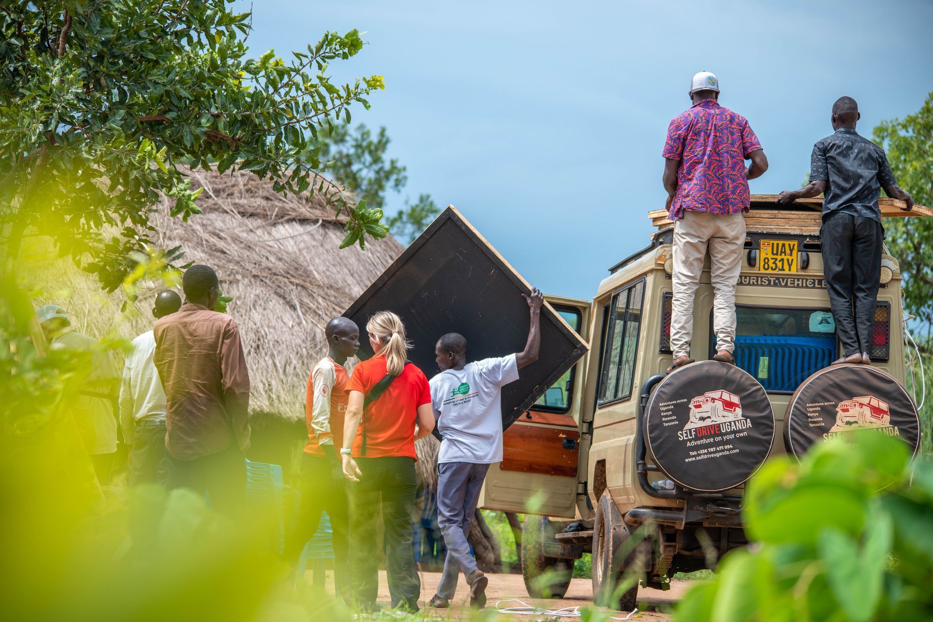 A group of people are standing around a jeep.