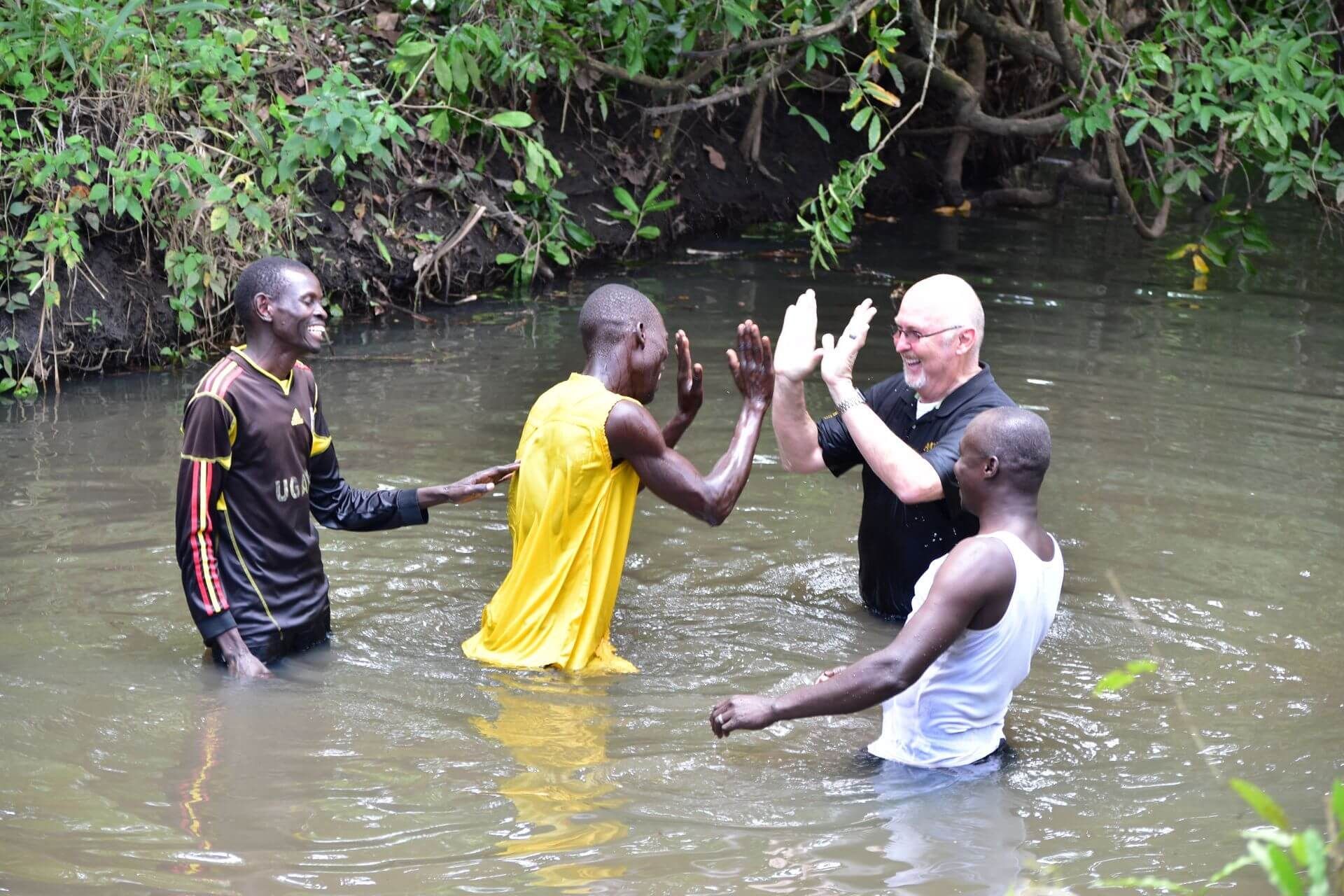Michael Ryer, CEO of Amigos, baptizes Martin Otum in river