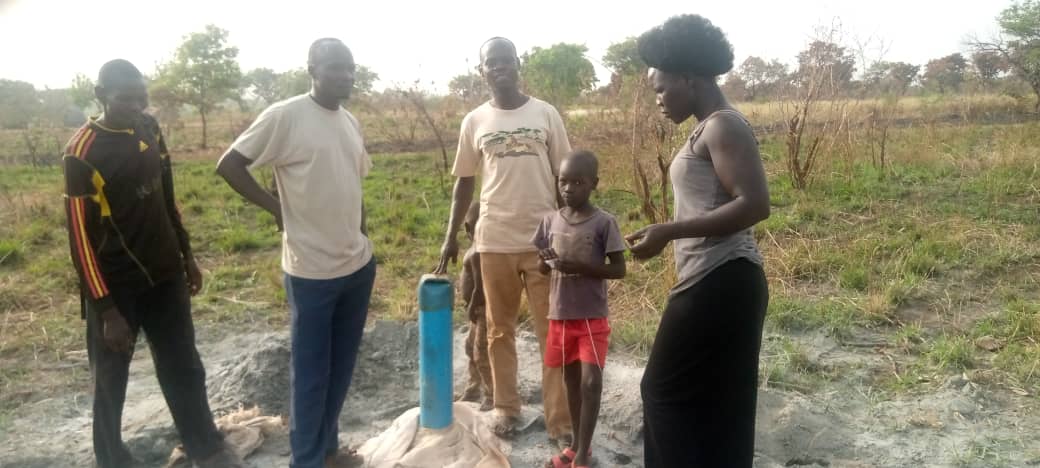 local village family inspecting the well freshly drilled
