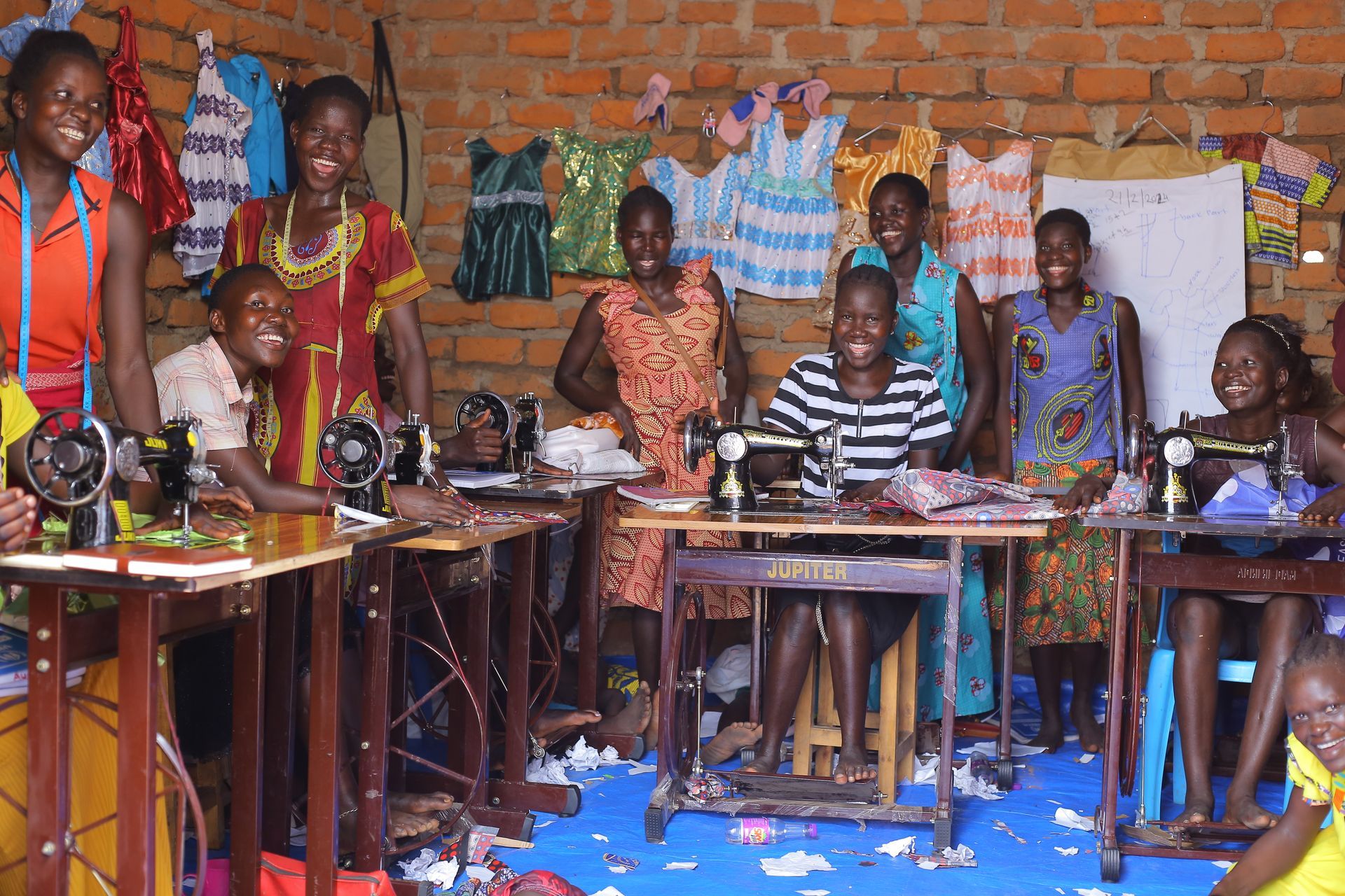 A group of children are sitting around sewing machines