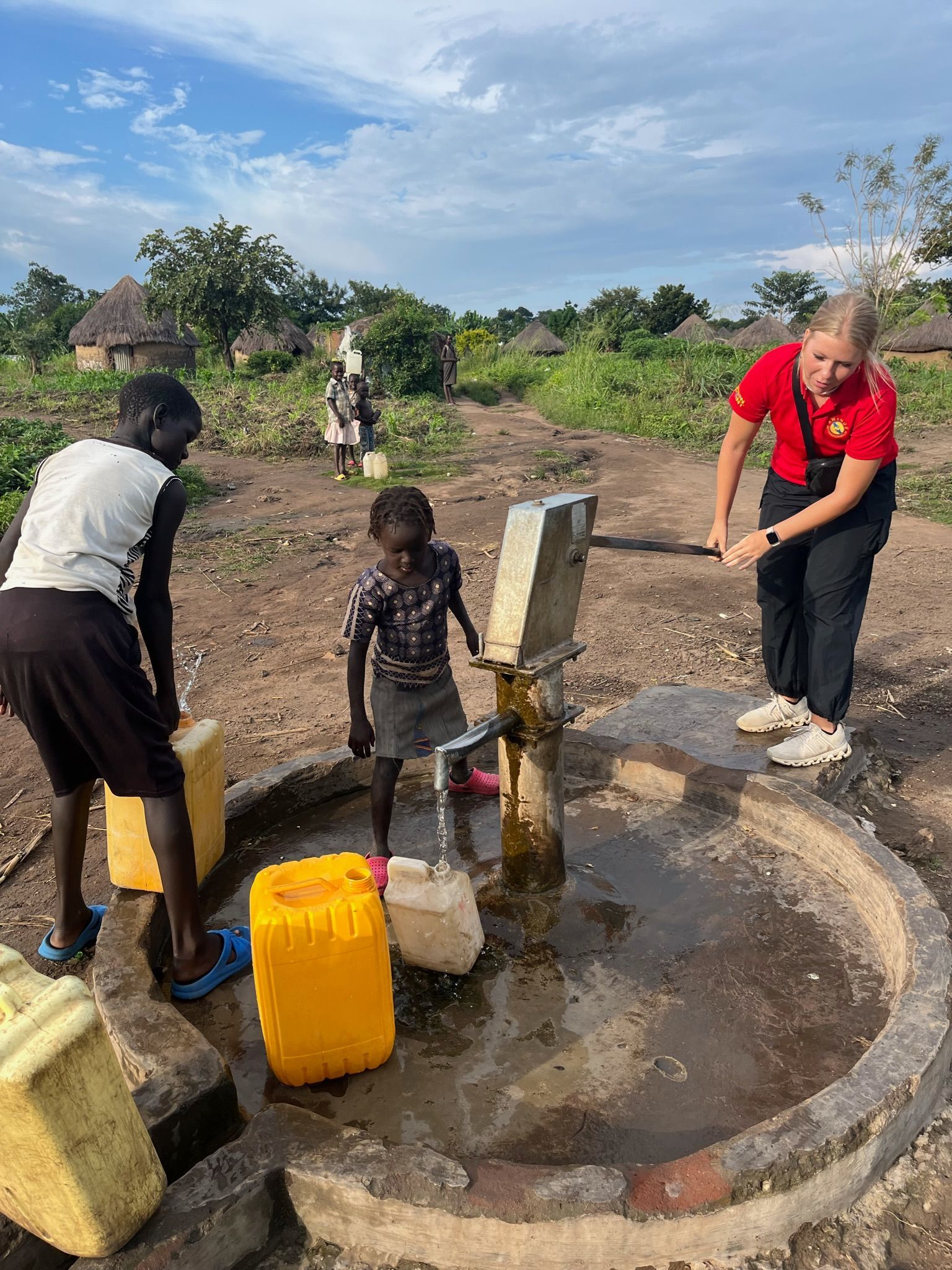 A group of children are gathering water from a well.