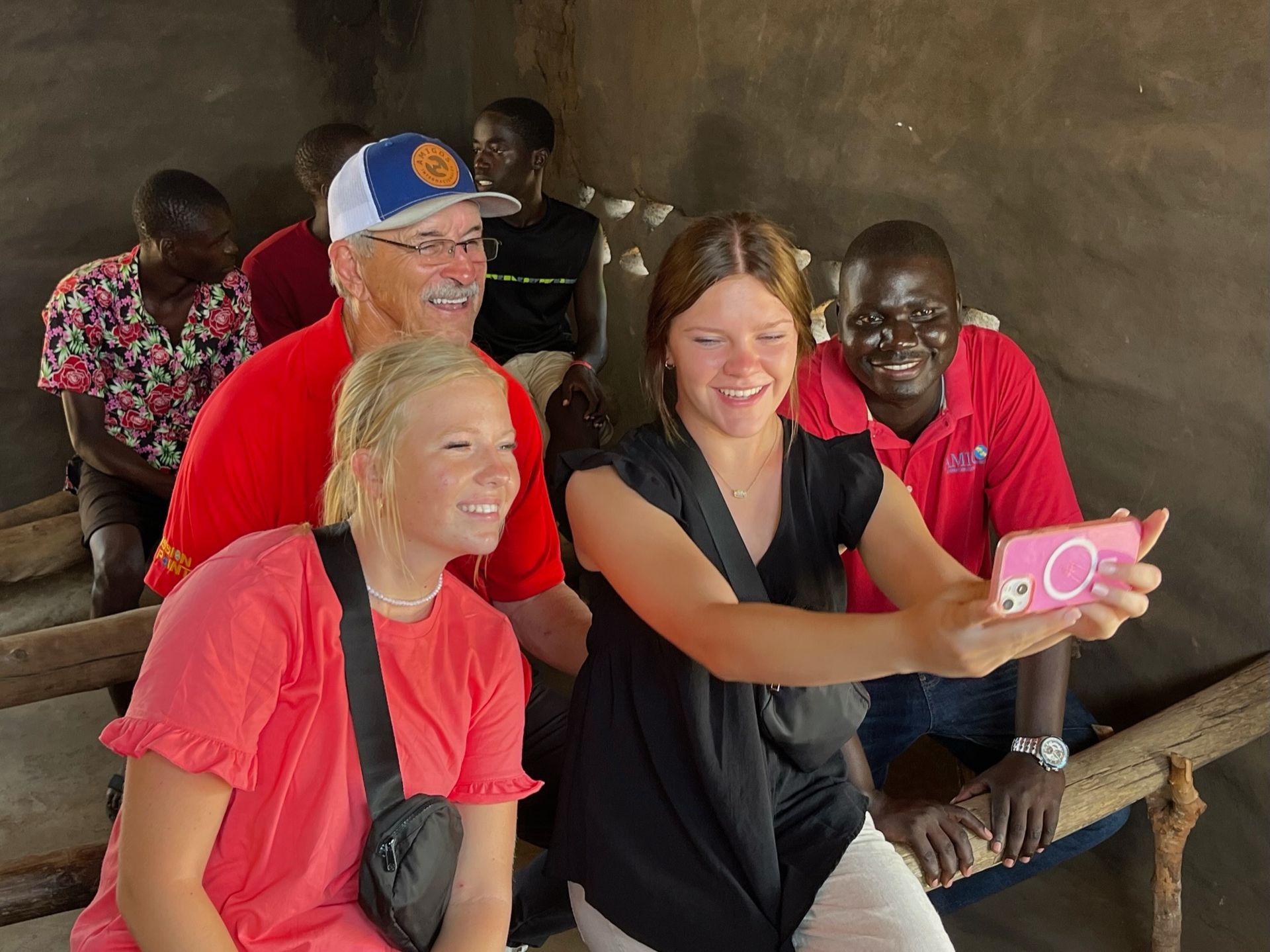 A group of people are taking a selfie with a cell phone.