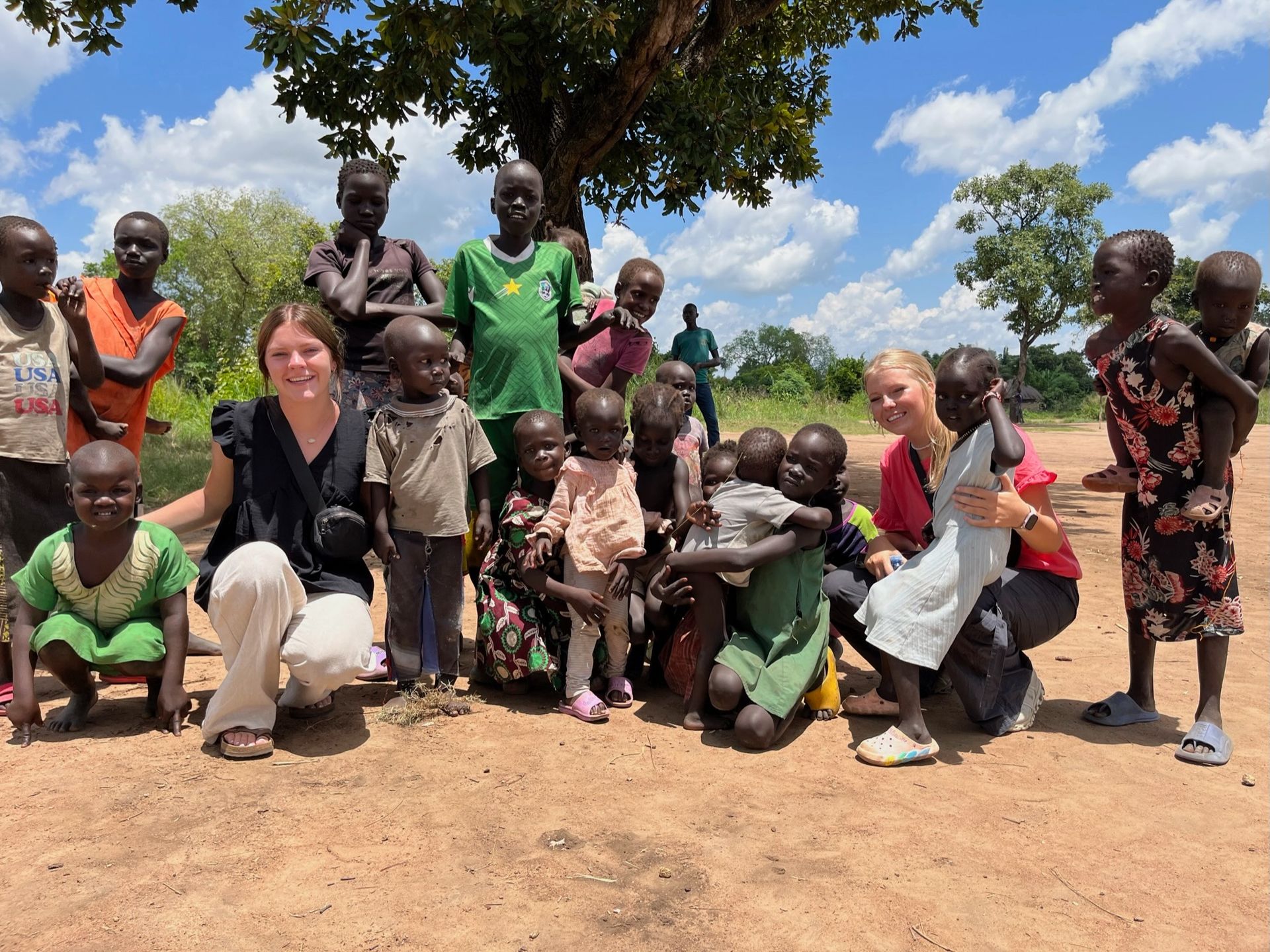 A group of people are posing for a picture with a tree in the background.