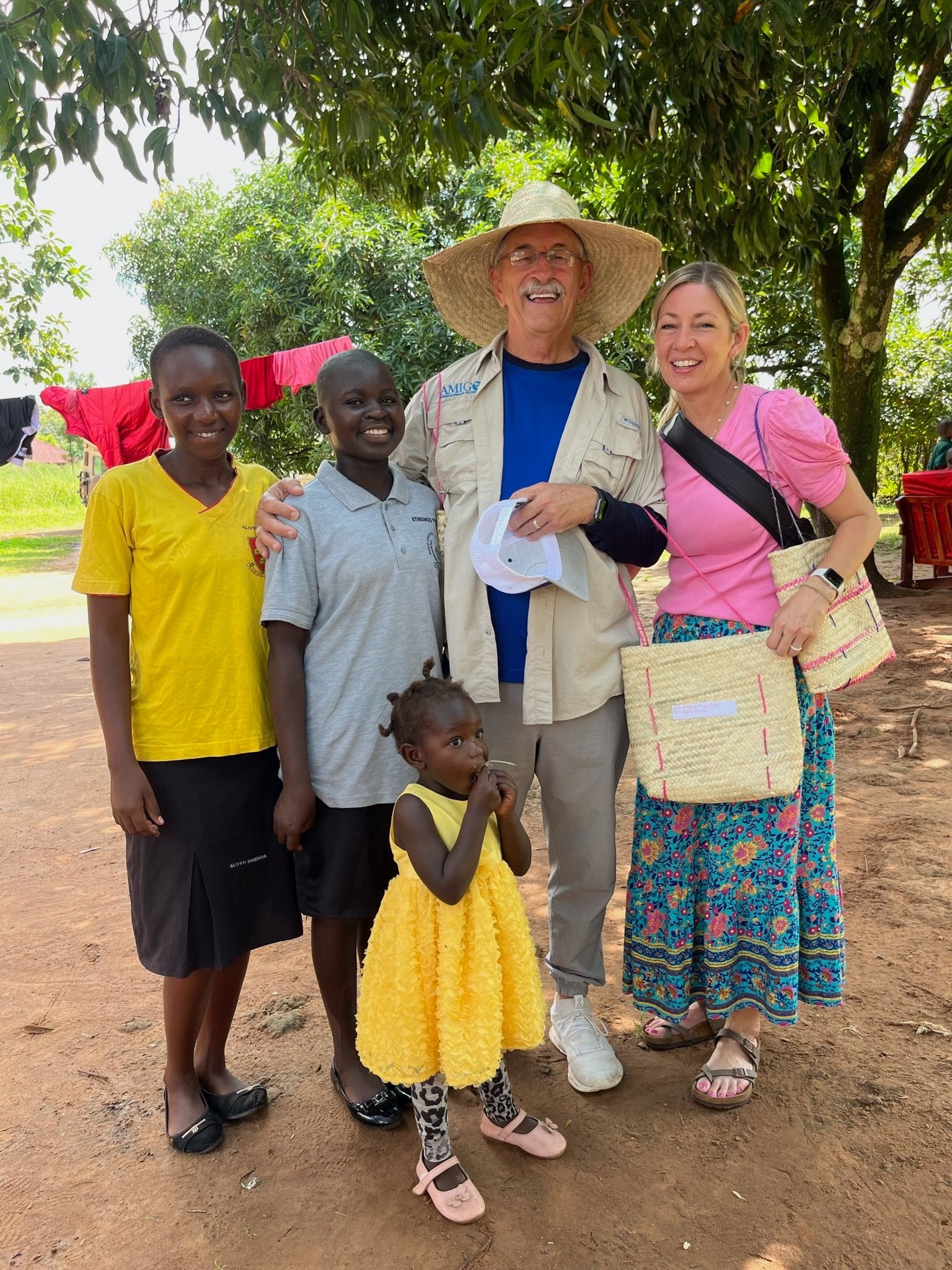 A group of people posing for a picture with a little girl in a yellow dress.