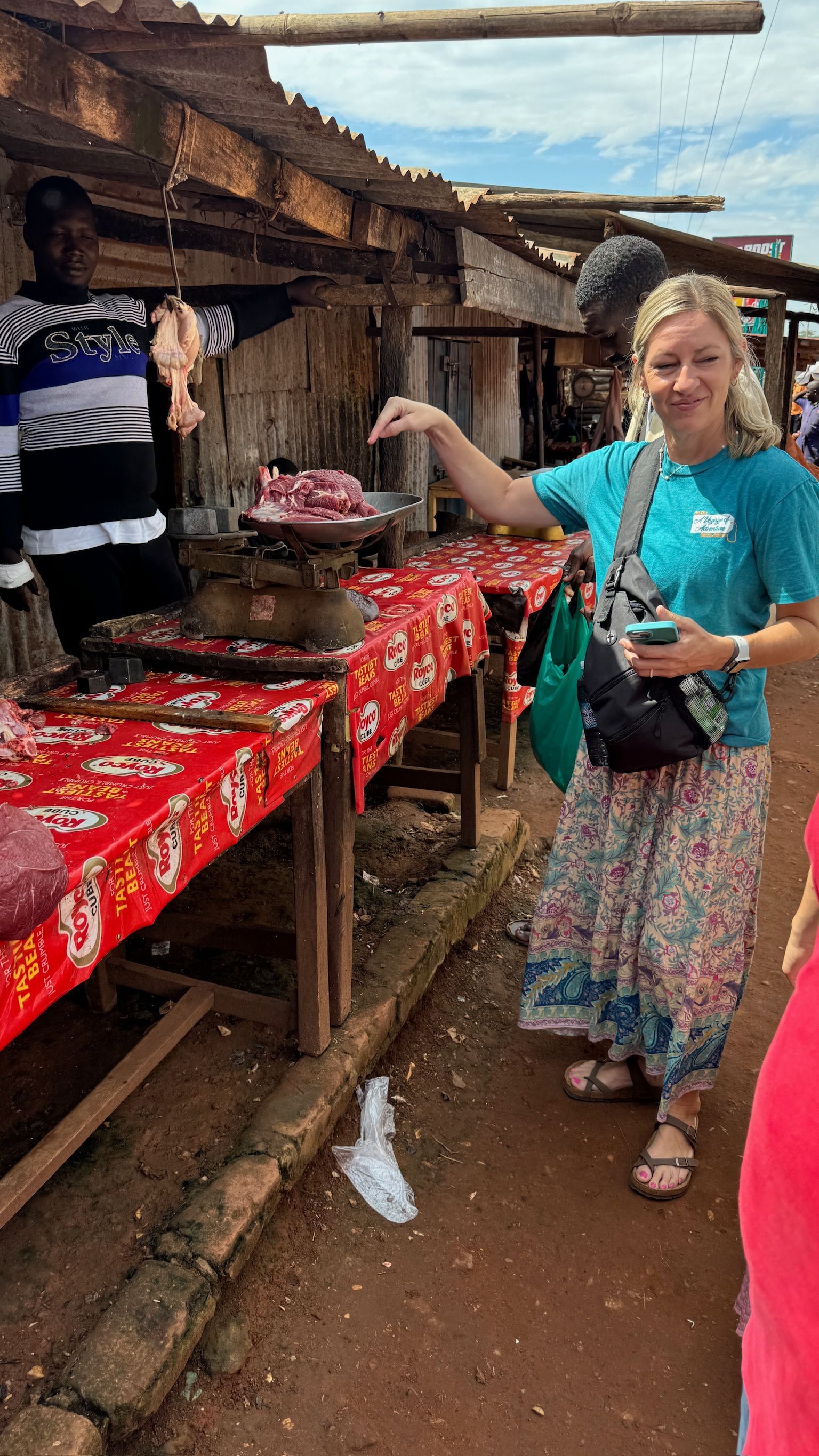 A woman is standing in front of a table at a market.