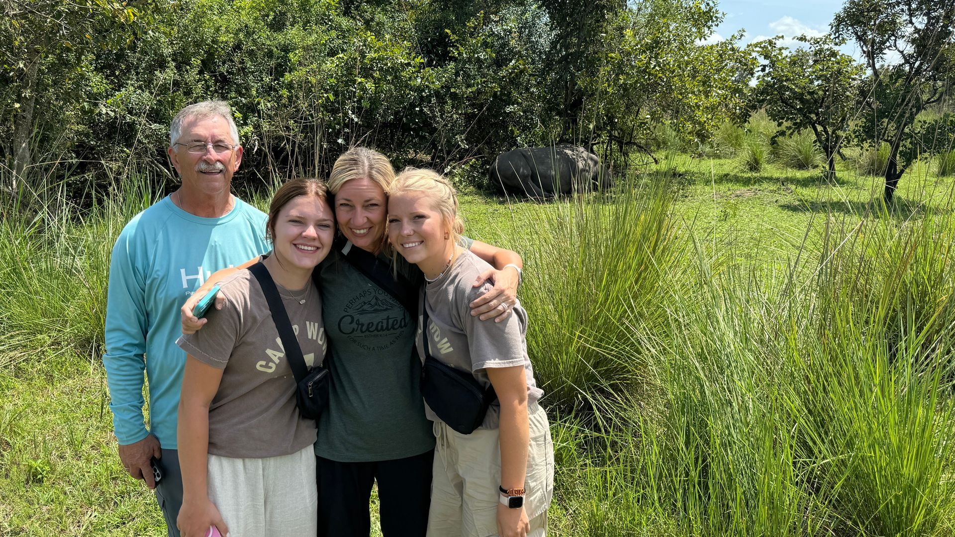 A group of people are posing for a picture in a field.