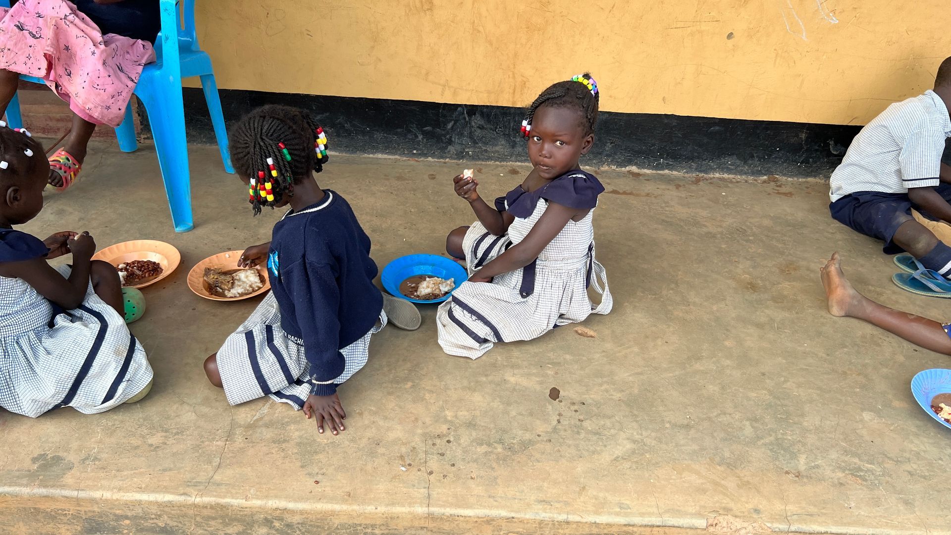 Starving African children at Amigos' school in Uganda enjoy a meal after school activities