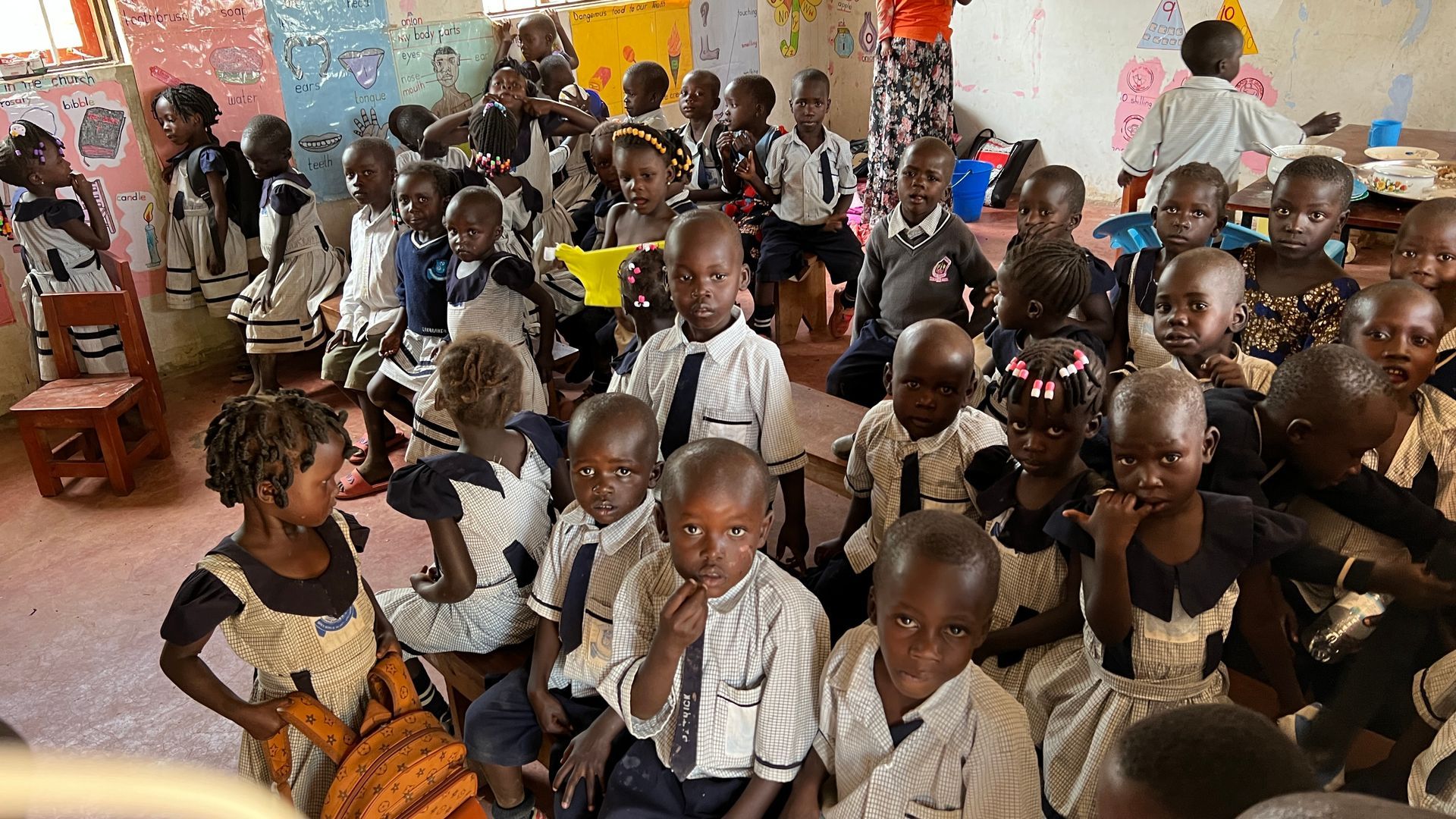 A large group of children are sitting in a classroom.