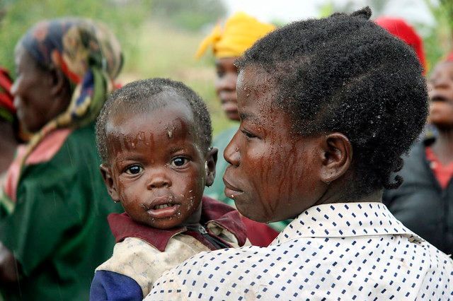 A woman is holding a baby in her arms.