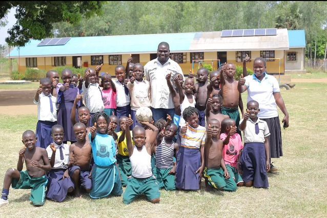 A group of children posing for a picture in front of a building