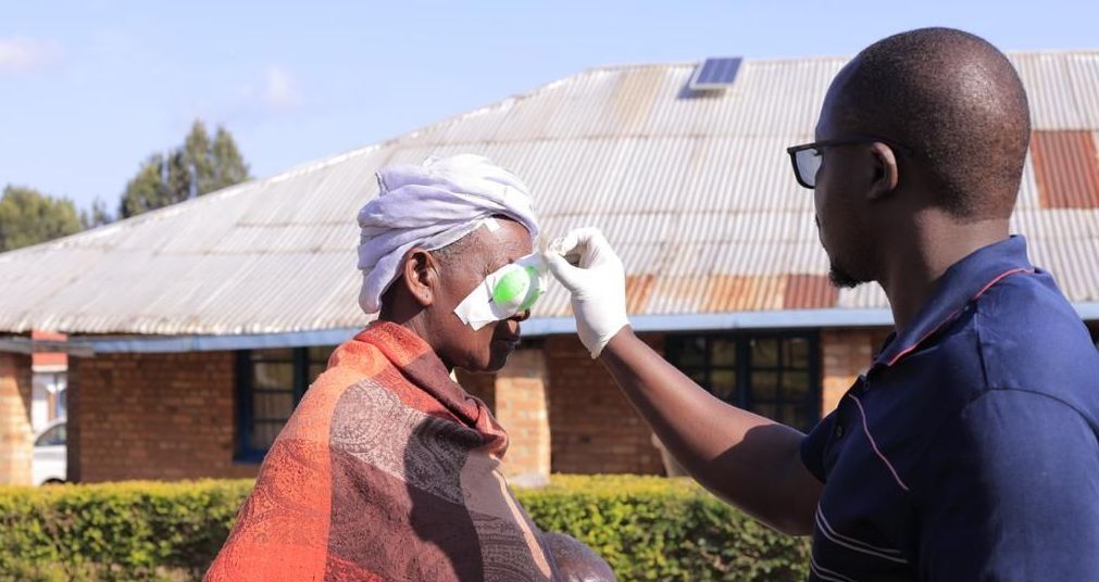 A man is taking a woman 's temperature with a thermometer.