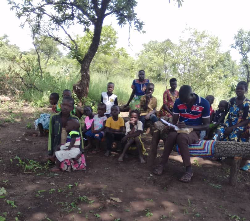 A group of people are sitting under a tree