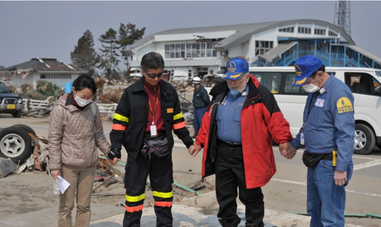 A group of people standing in a parking lot holding hands